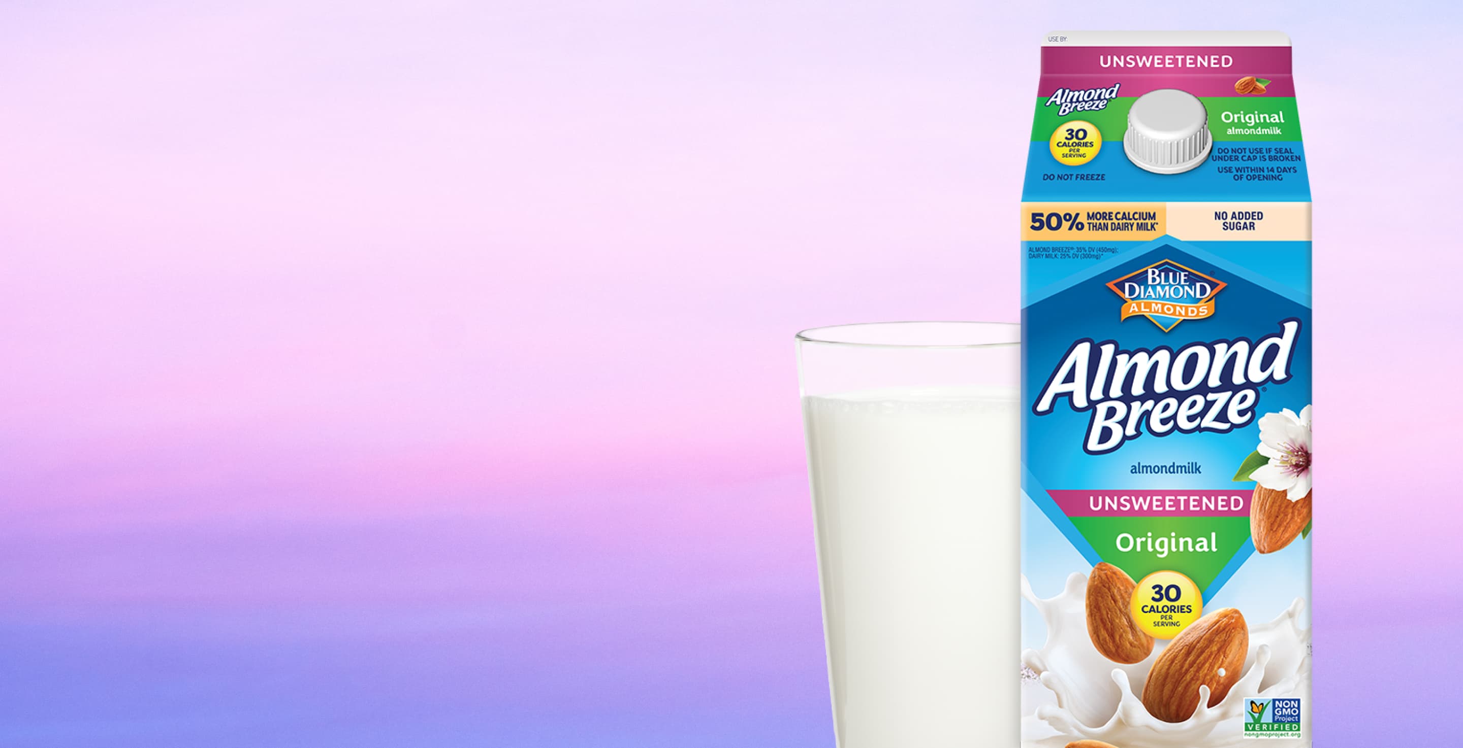 Carton and glass of almond breeze almond milk with a purple background