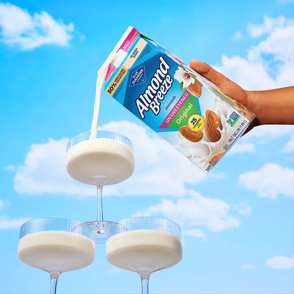 Almond breeze carton pouring into glasses