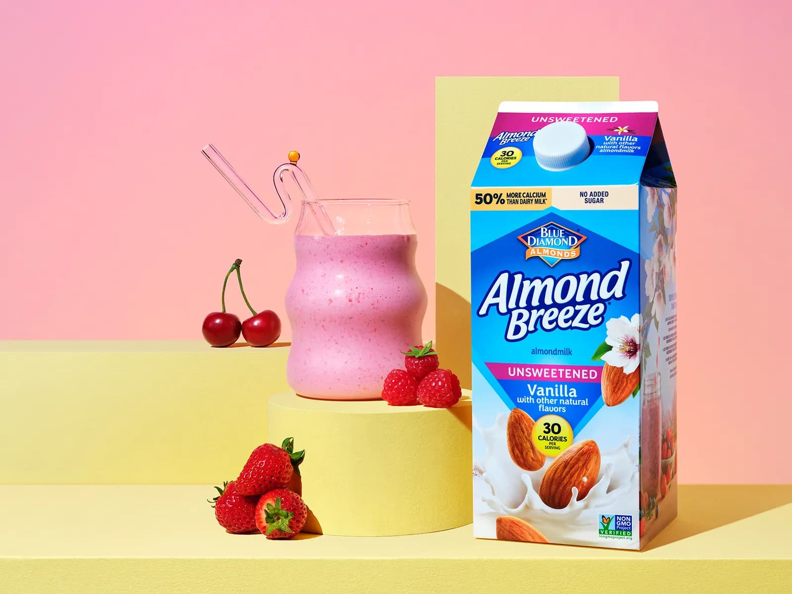 Almond breeze unsweetened vanilla carton on display next to a glass and fruit