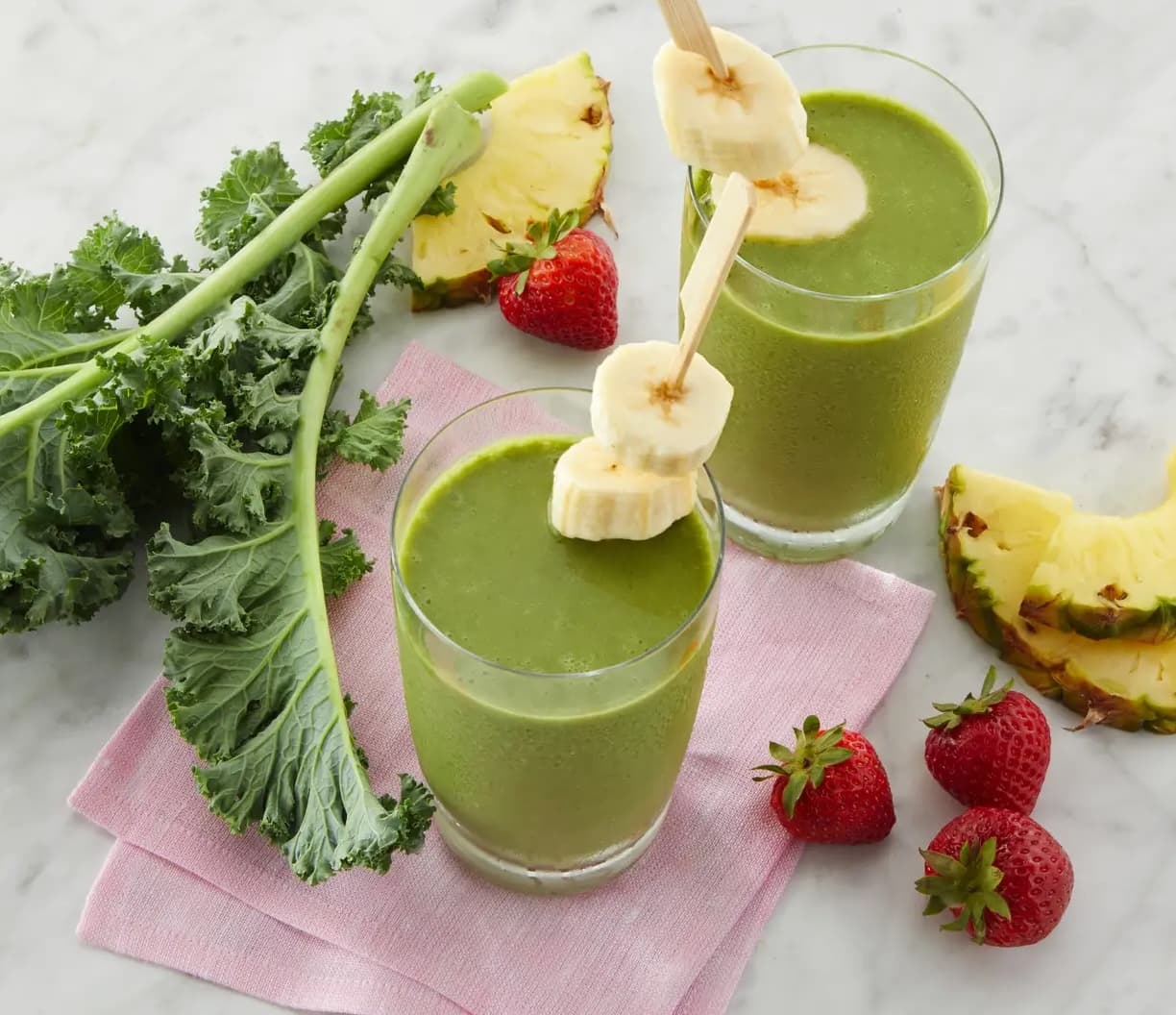 Glasses of smoothies surrounded by fruit