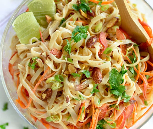 Bowl of thai coconut noodles topped with whole Blue Diamond Roasted Salted Almonds