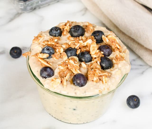 Bowl of dairy-free blueberry overnight oats topped with fresh blueberries