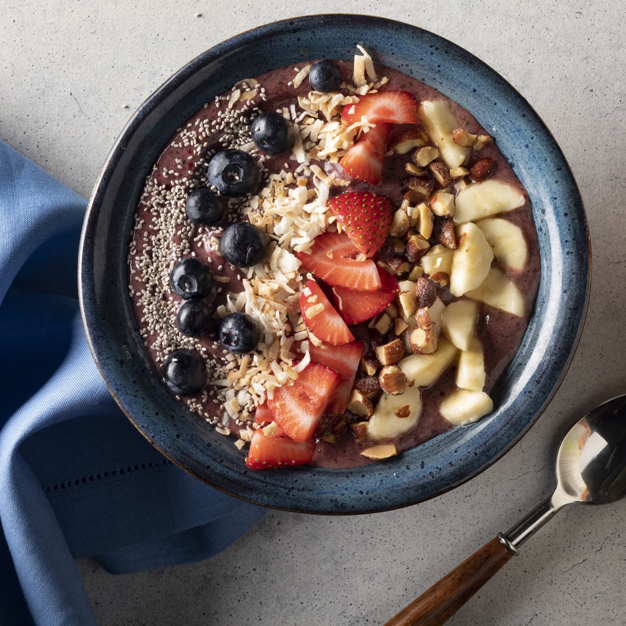 Bird's eye view of the berry banana smoothie bowl topped with fresh berries and Blue Diamond Toasted Coconut Almonds