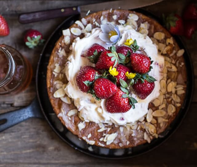 Freshly baked honey almond cake topped with whipped cream, whole strawberries and Blue Diamond Almond shavings