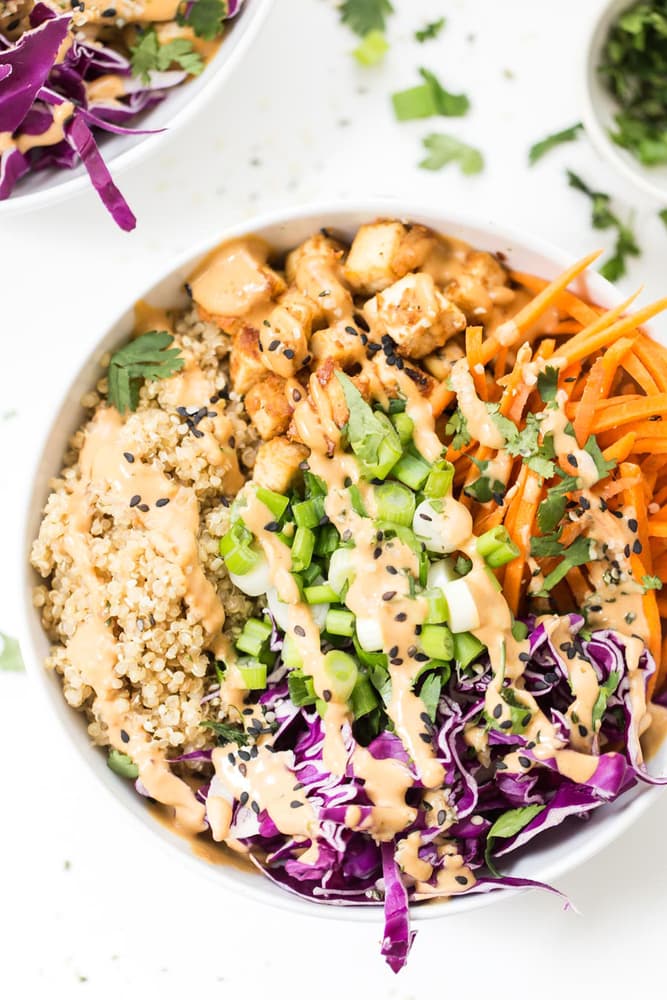 Asian quinoa bowl with peanut baked tofu topped with sesame seeds
