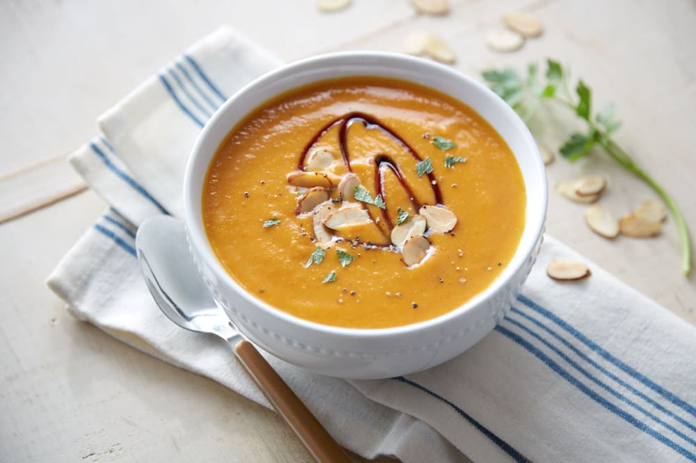 Bowl of pumpkin bisque topped with shaved Blue Diamond Almonds