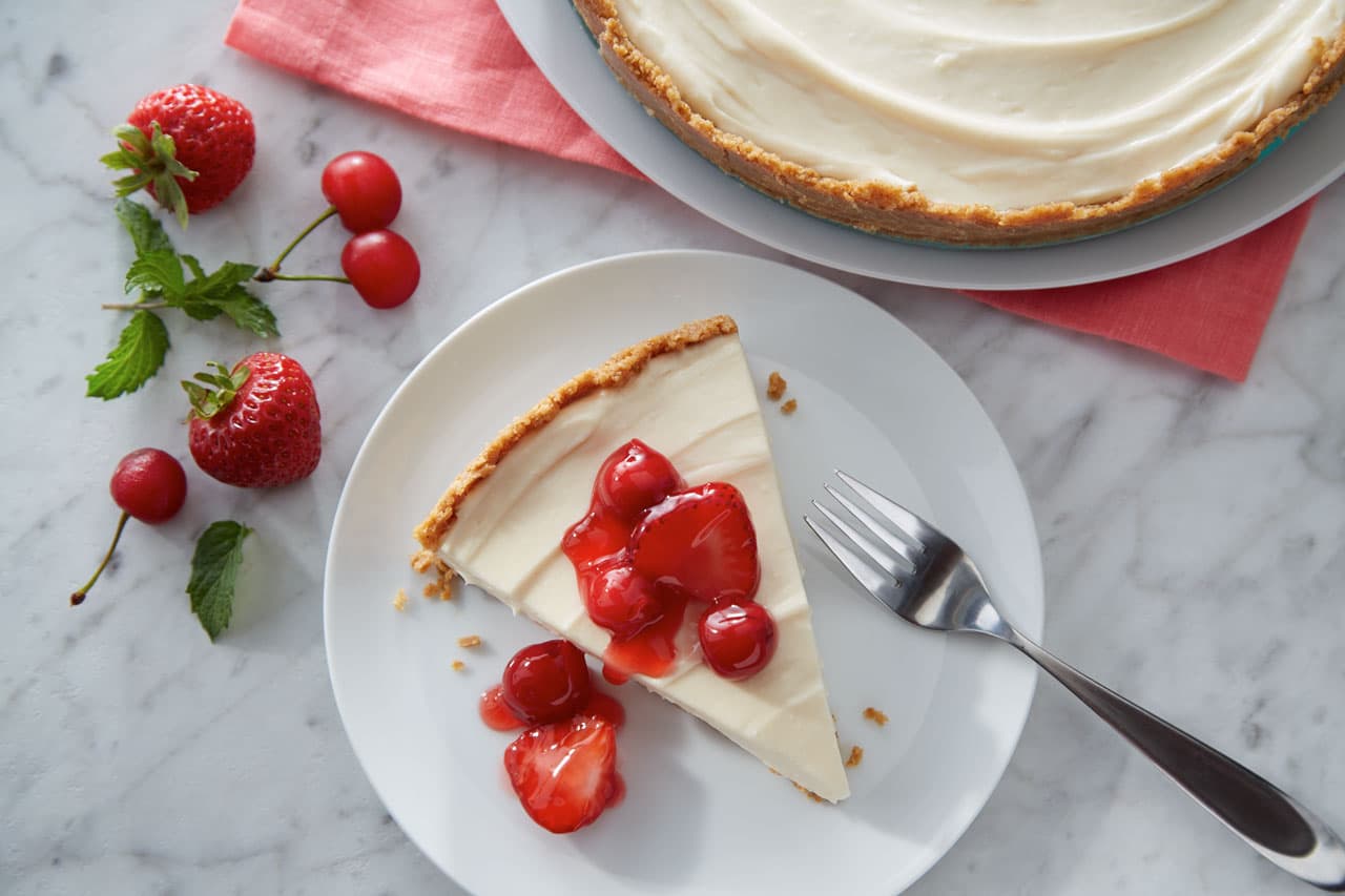 Slice of no bake cheesecake topped with fresh strawberries