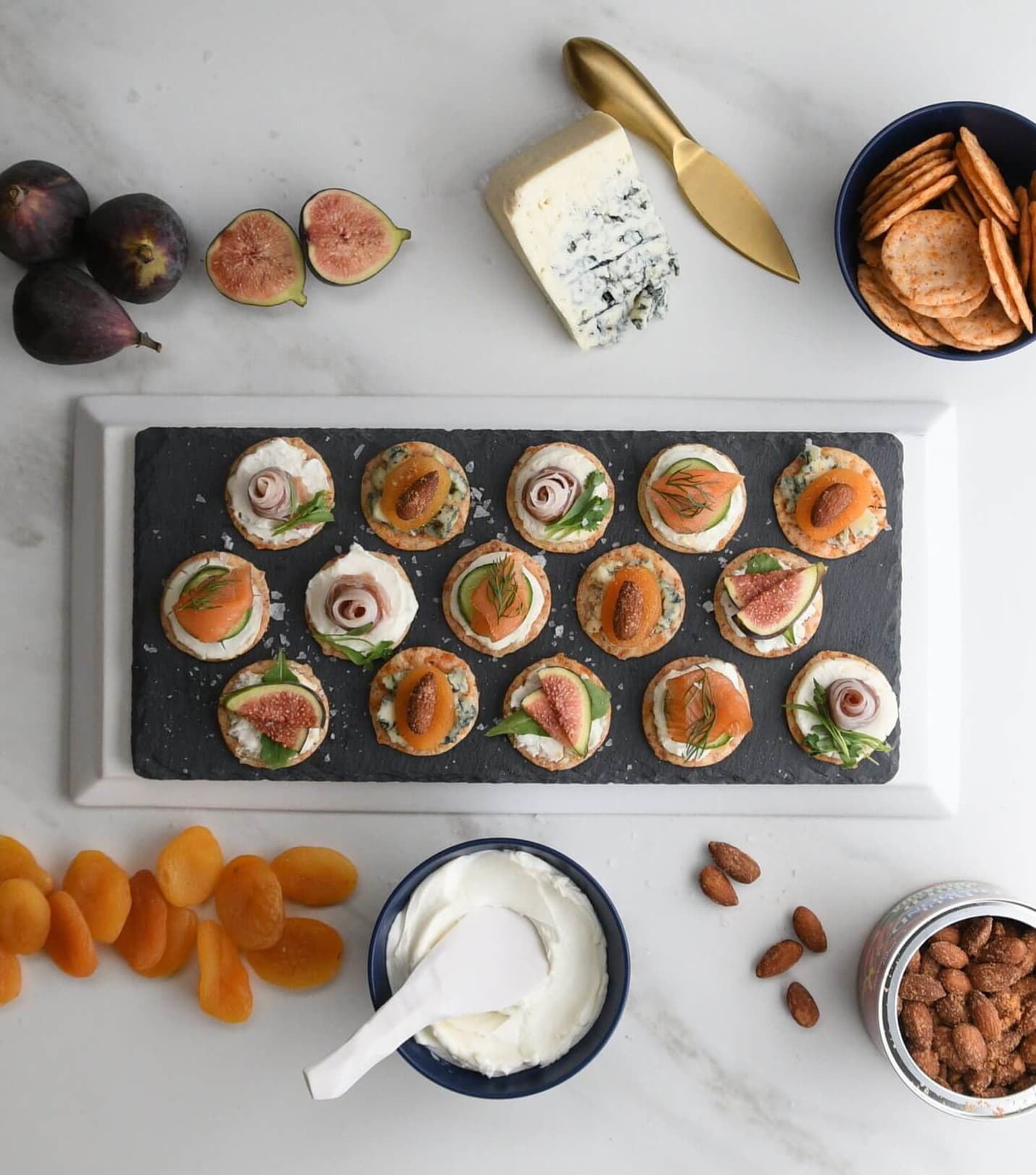 Platter of charcuterie bites made with fresh figs, dried apricots, and Blue Diamond Nut Thins Sriracha Crackers