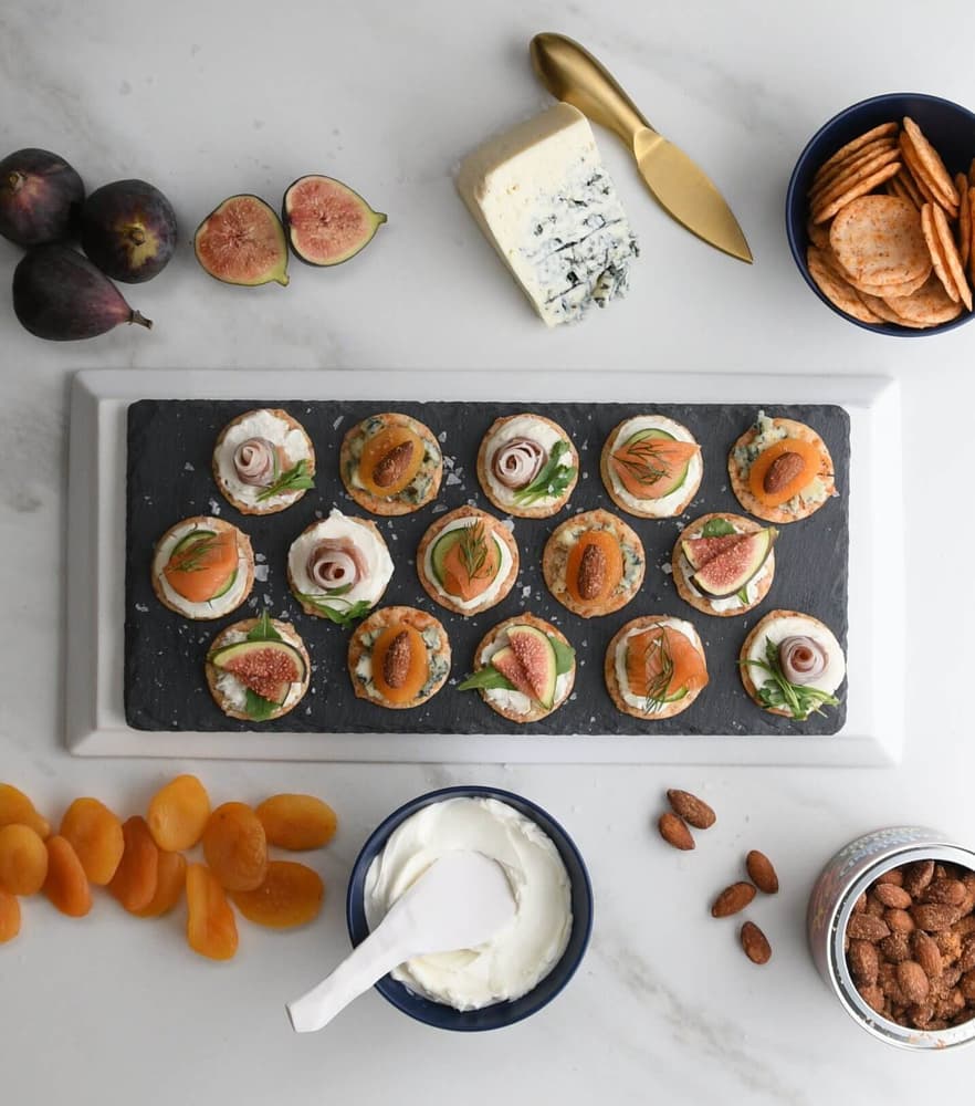 Platter of charcuterie bites made with fresh figs, dried apricots, and Blue Diamond Nut Thins Sriracha Crackers