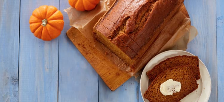 Pumpkin bread with small pumpkins on a blue table