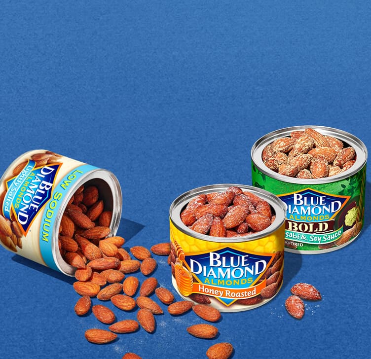 Assorted snack almonds on a noisy blue background texture