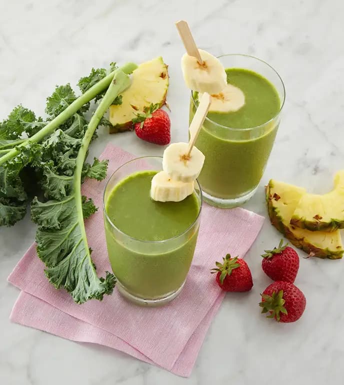 Tropical smoothie made with pineapple, strawberry, banana, and kale.