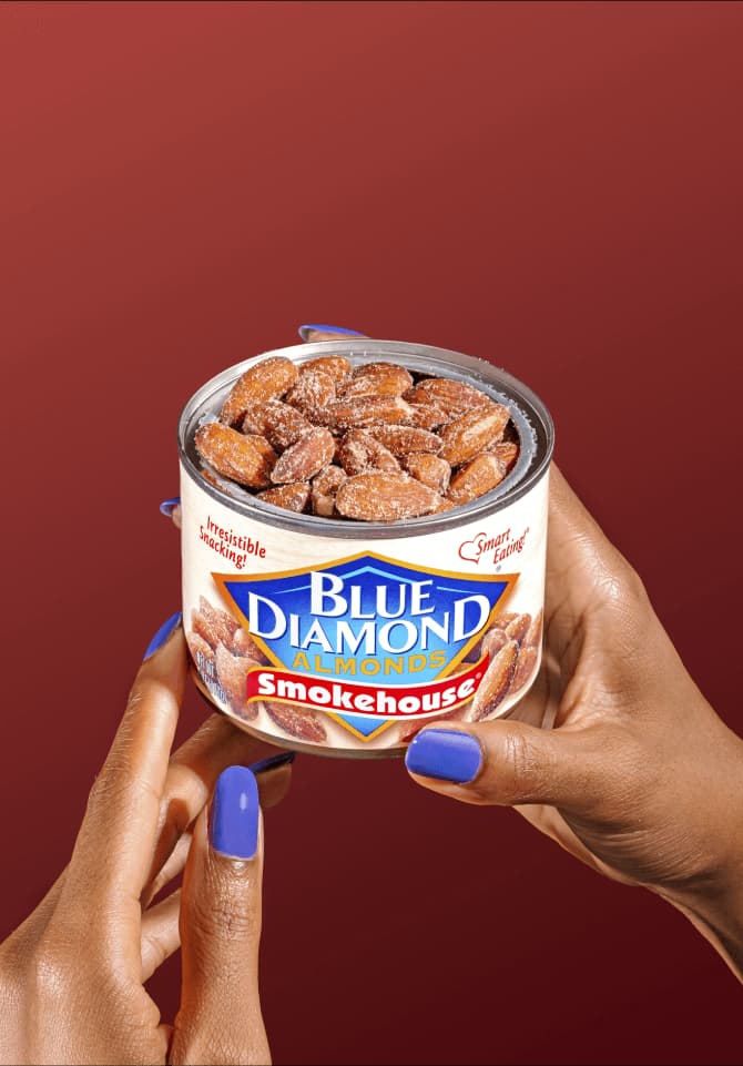 A woman's hands holding a can of Blue Diamond Smokehouse Almonds.