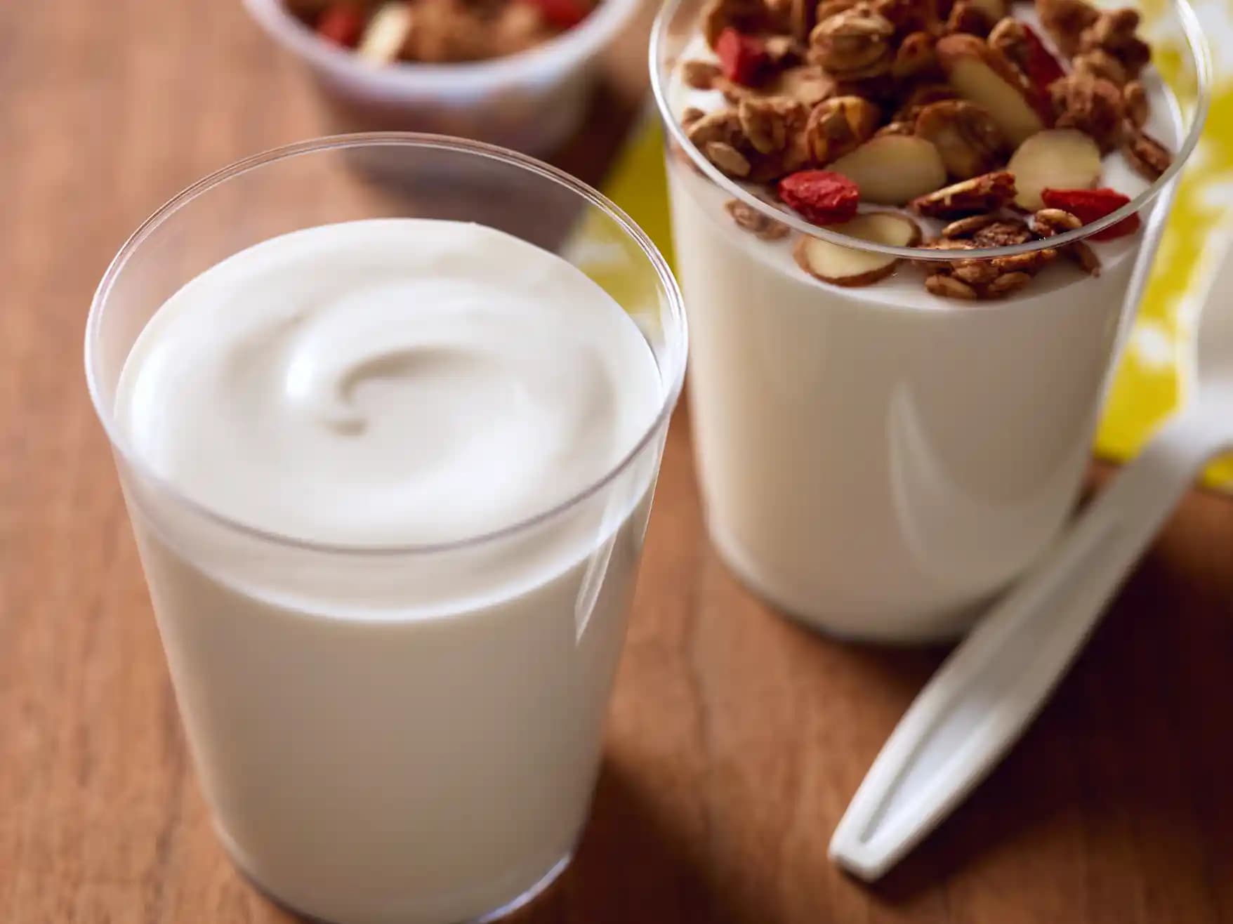 Close up showing whipped almond-based yogurt with sliced almonds and fruit in a clear glass