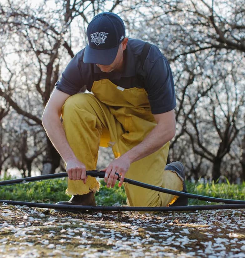 Person adjusting irrigation hose