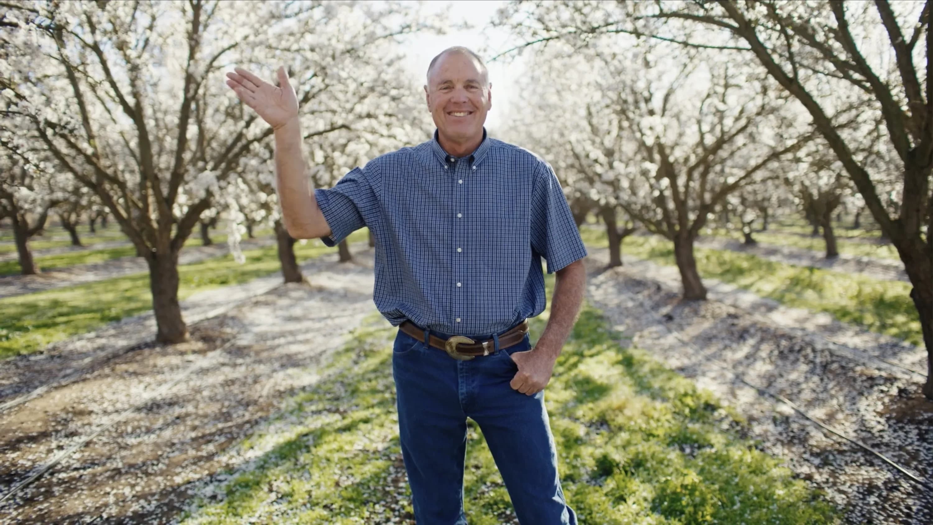 Person waiving standing in a field